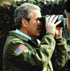 G. Bush looking through binoculars still covered